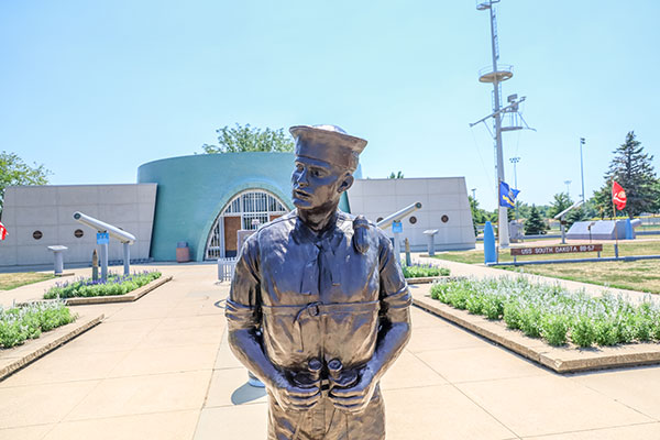 statue of a sailor standing outside of the USS South Dakota Memorial 